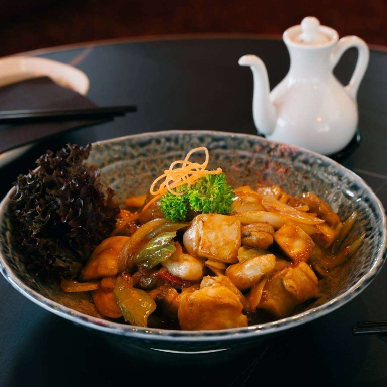 Chicken stir-fry with vegetables and cashews served in a ceramic bowl at Wok O’Clock Cairns.